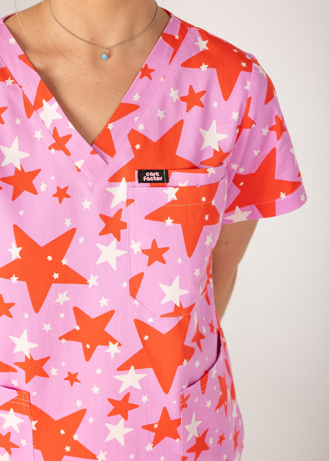 person wearing a purple and red star pair of fun scrubs