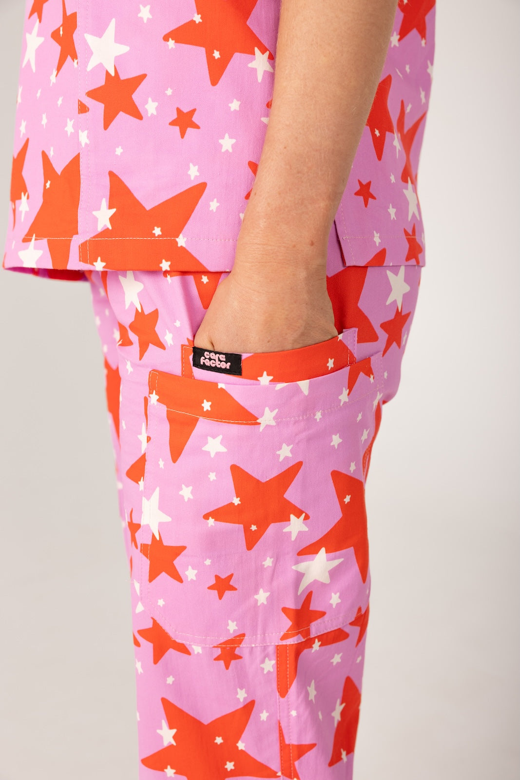 person wearing a purple and red star pair of fun scrubs