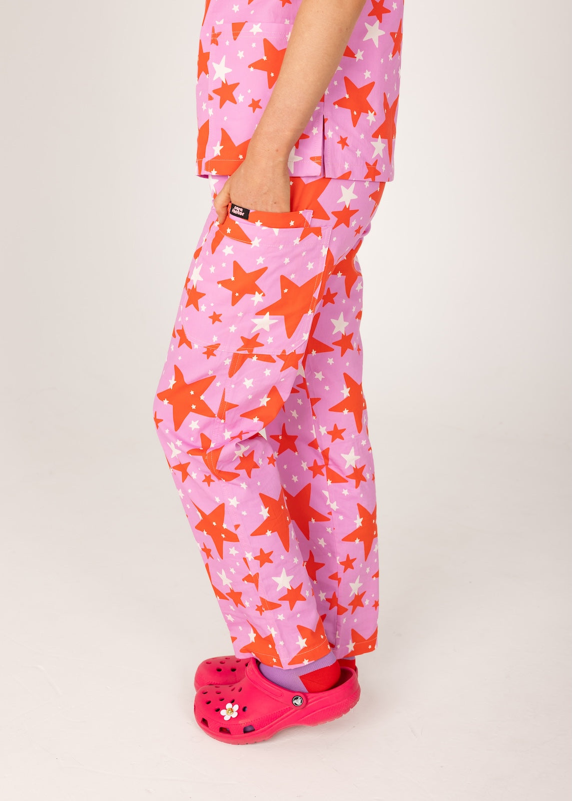 person wearing a purple and red star pair of fun scrubs