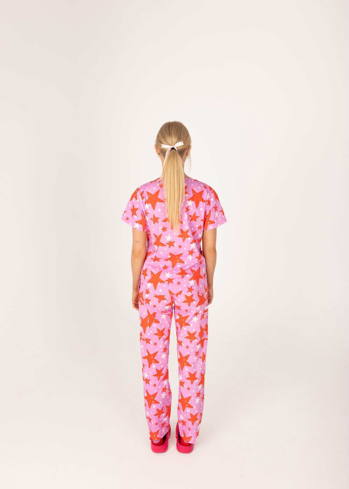 person wearing a purple and red star pair of fun scrubs