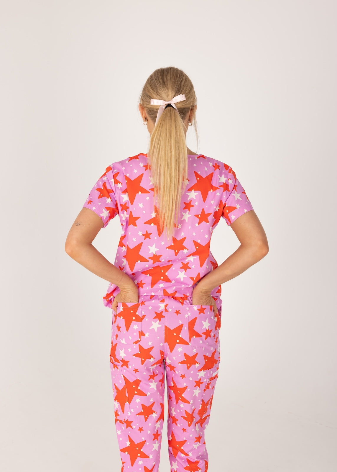 person wearing a purple and red star pair of fun scrubs