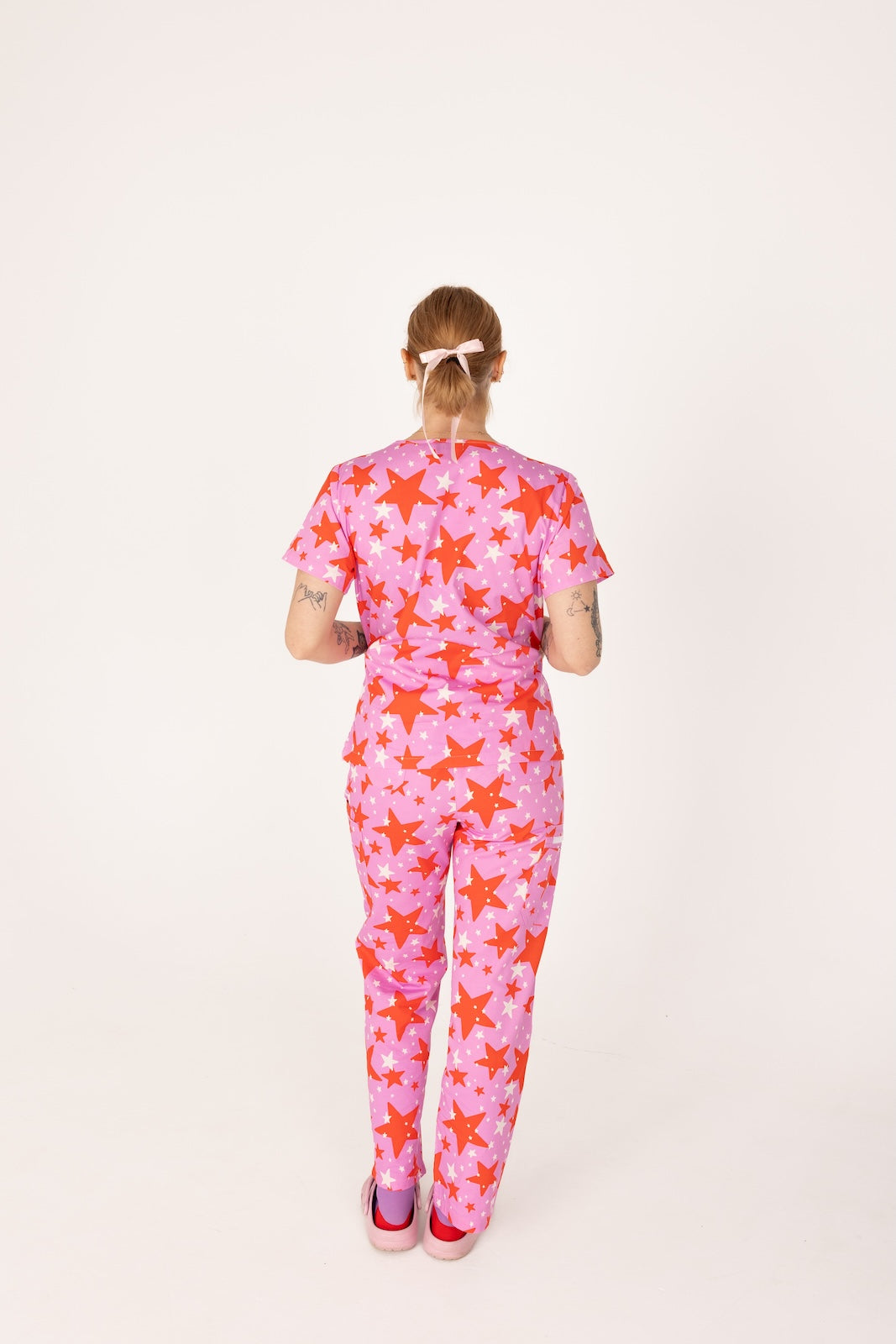 person wearing a purple and red star pair of fun scrubs