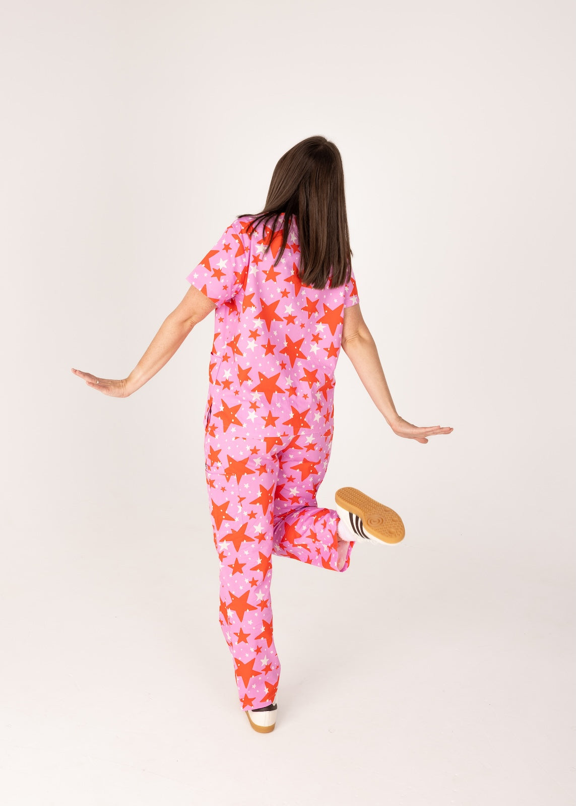 person wearing a purple and red star pair of fun scrubs