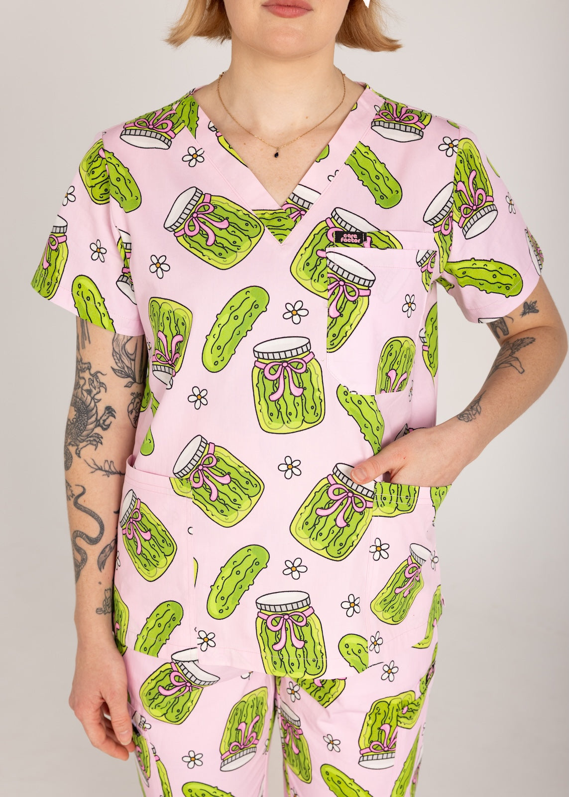 Person wearing pink fun scrubs with pickle pattern