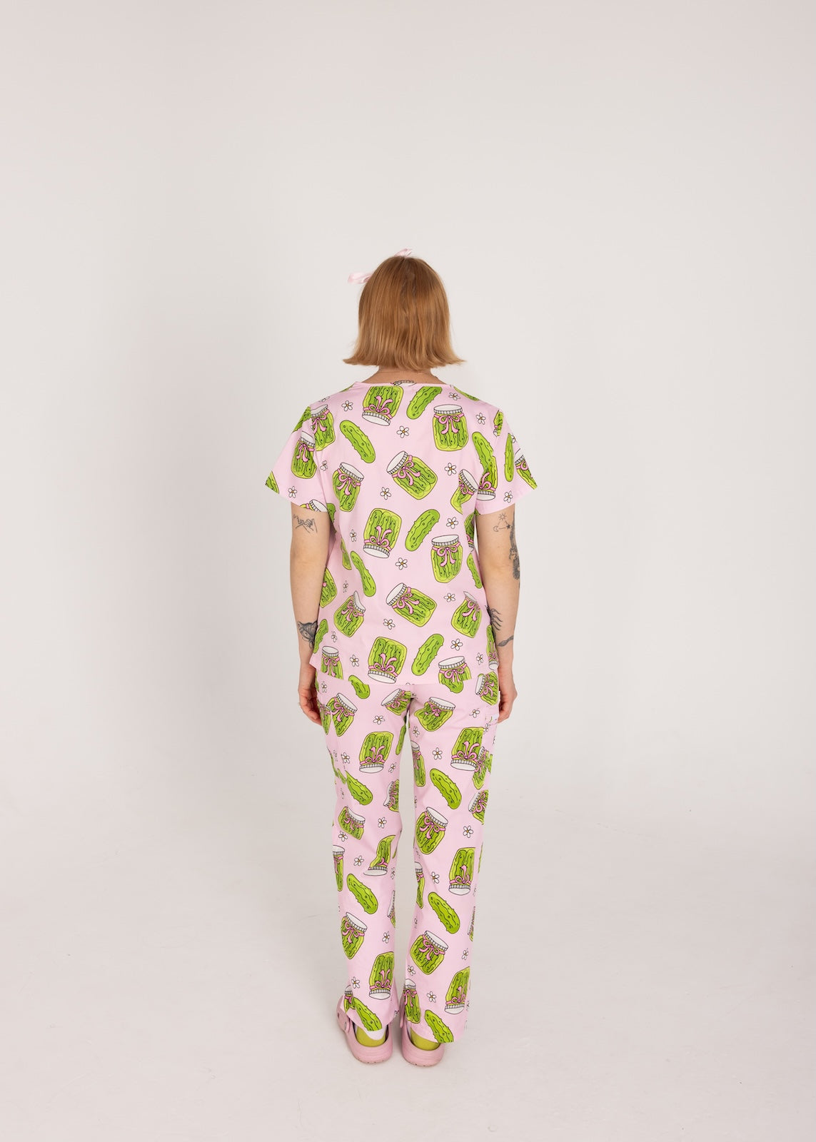 Person wearing pink fun scrubs with pickle pattern