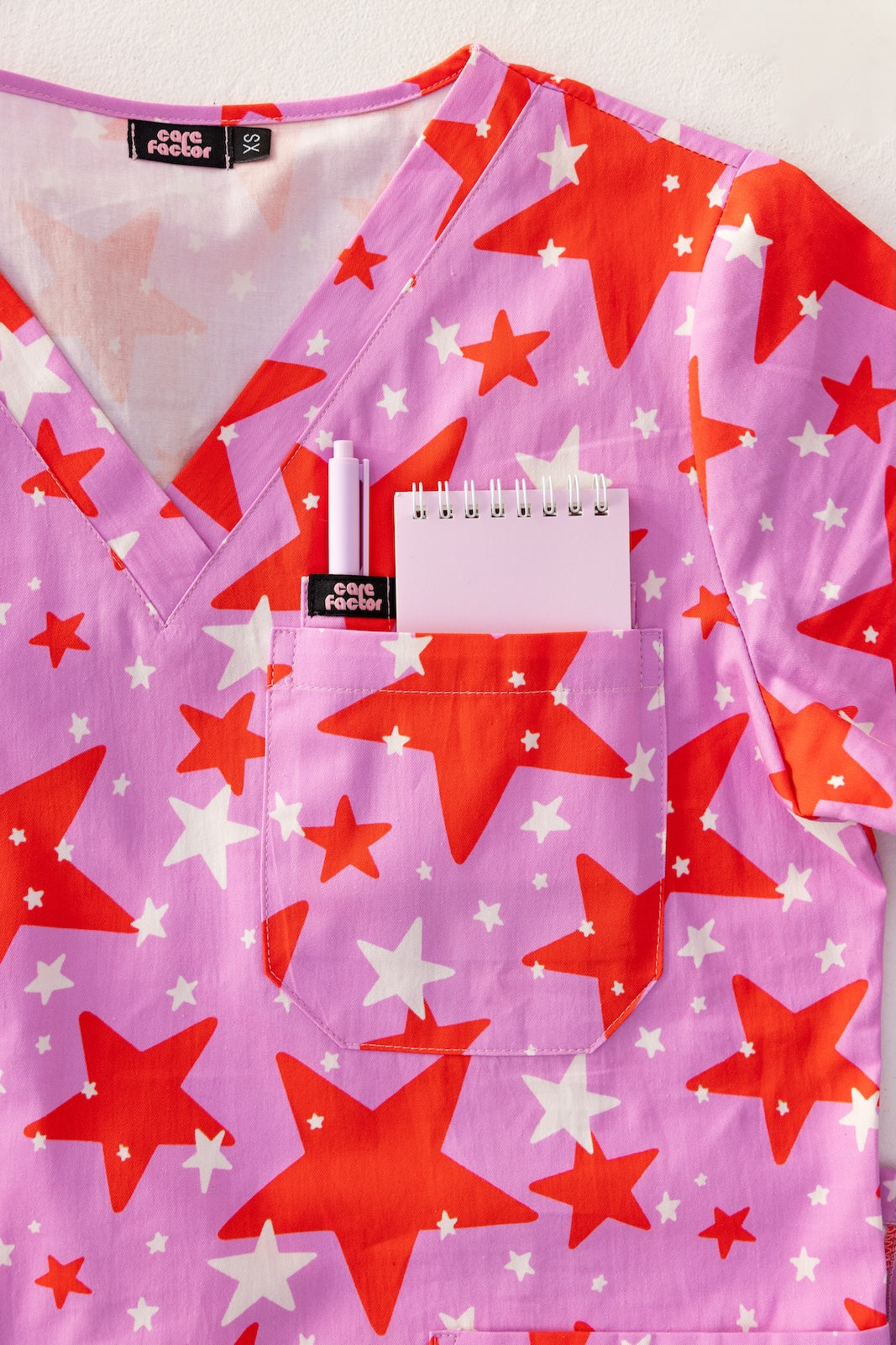 person wearing a purple and red star pair of fun scrubs