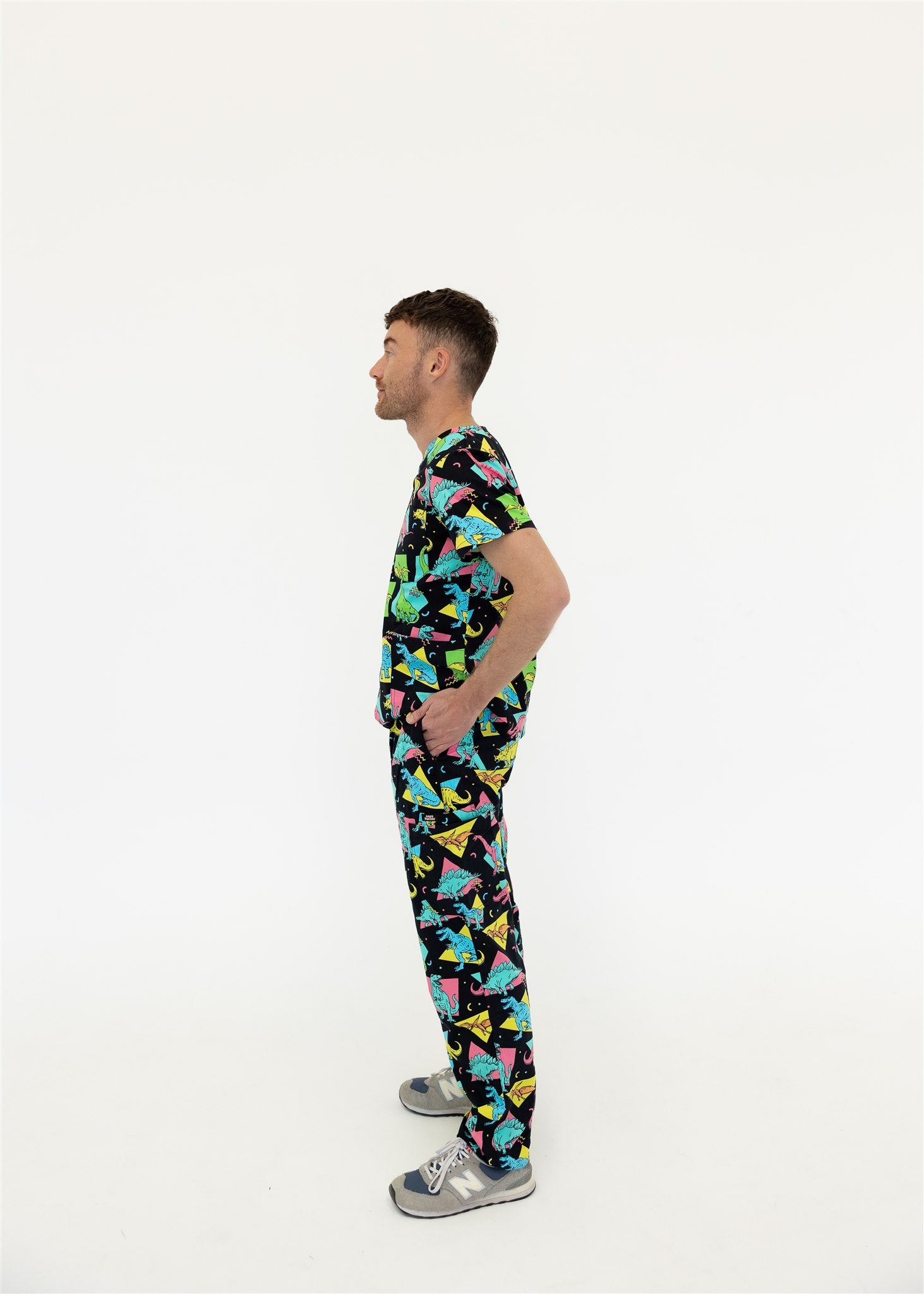 man in black and bright colour retro Dino scrub set