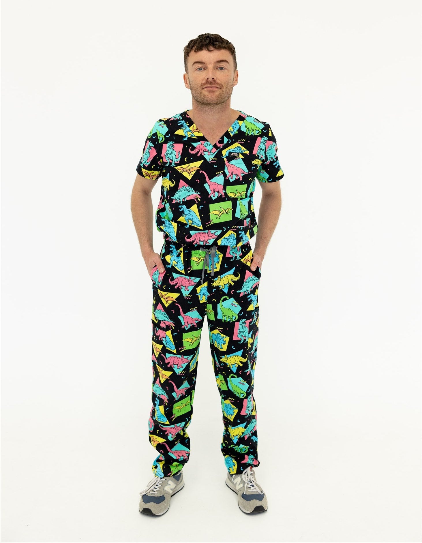 man in black and bright colour retro Dino scrub set