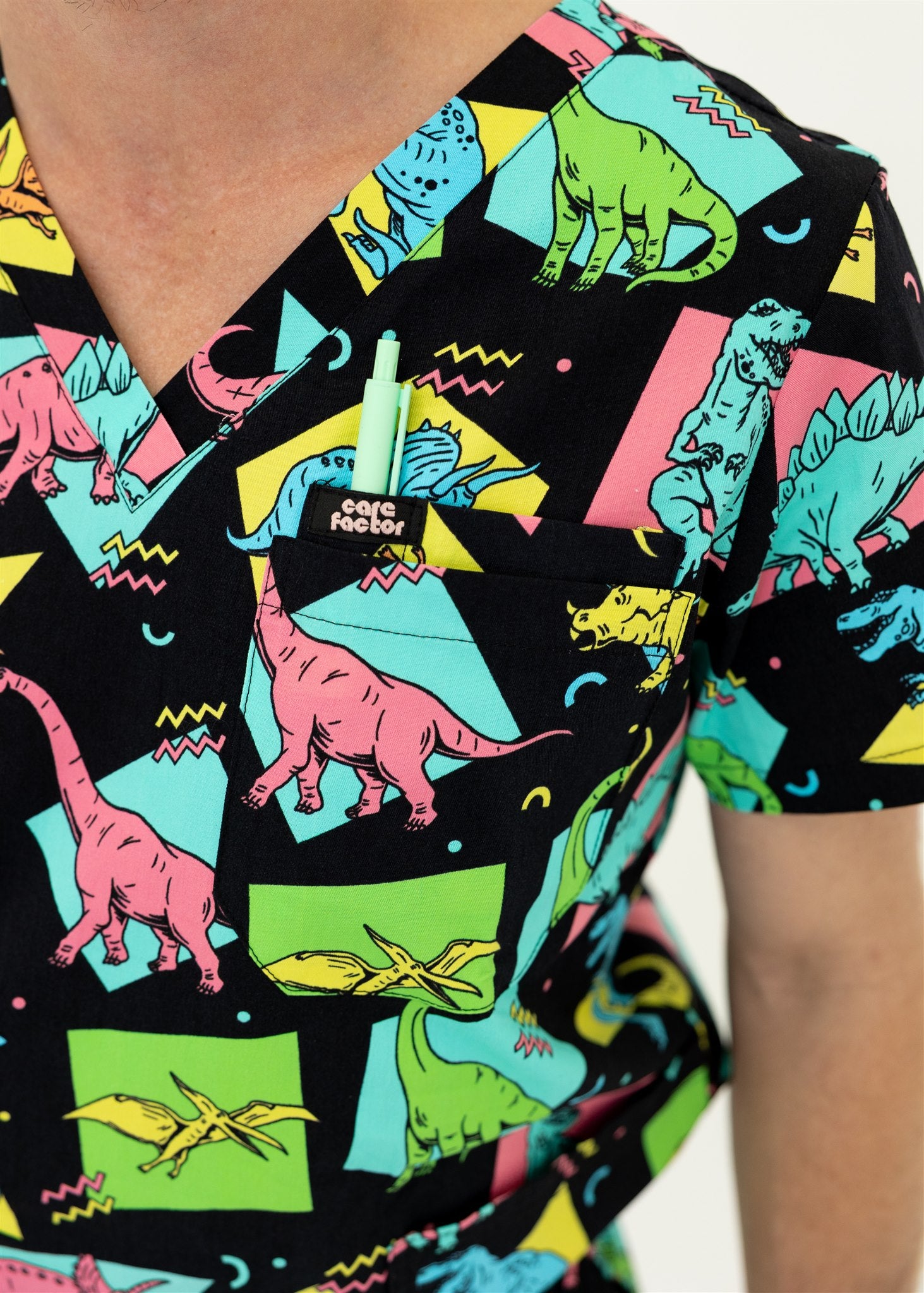 man in black and bright colour retro Dino scrub set top