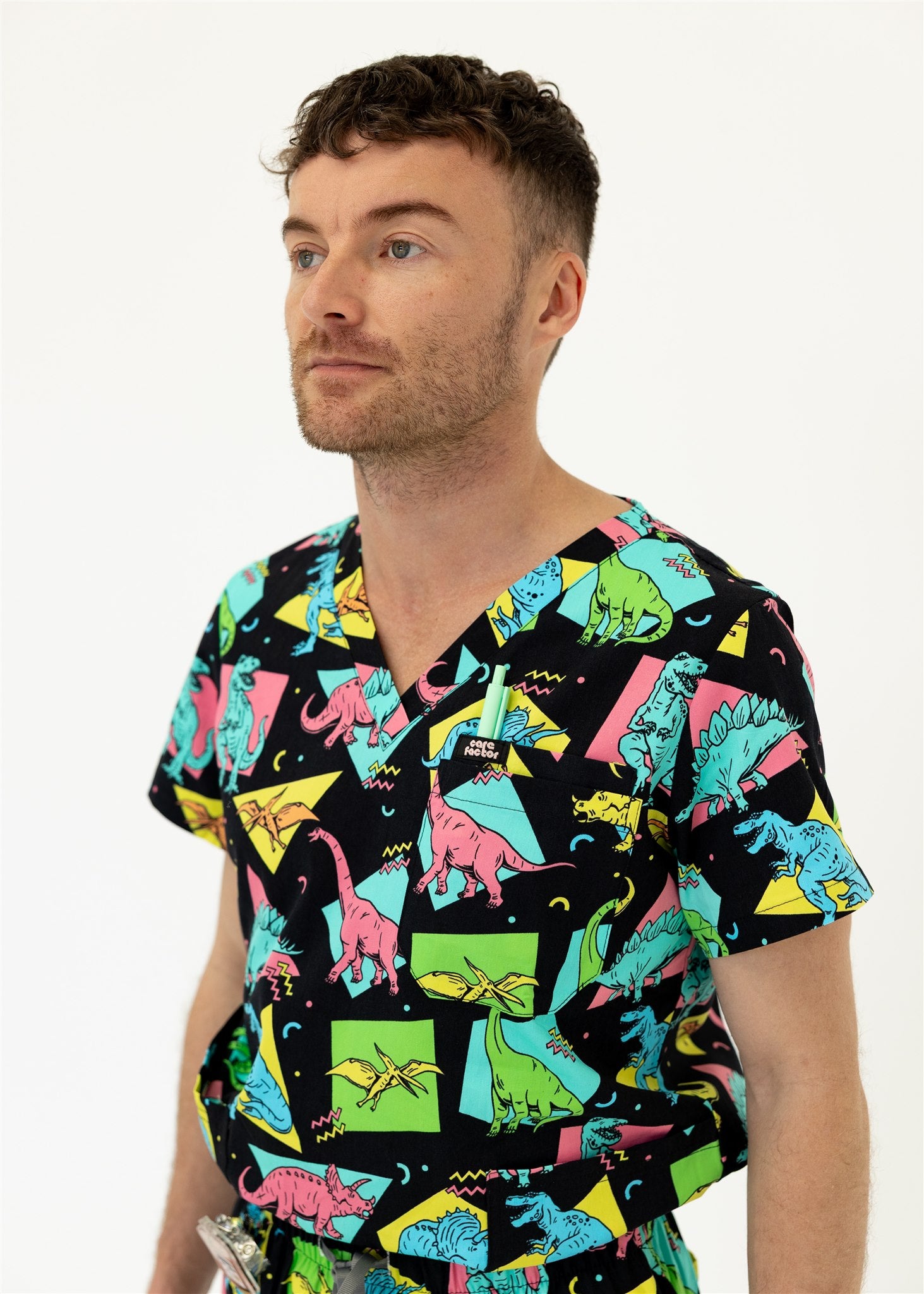 man in black and bright colour retro Dino scrub set