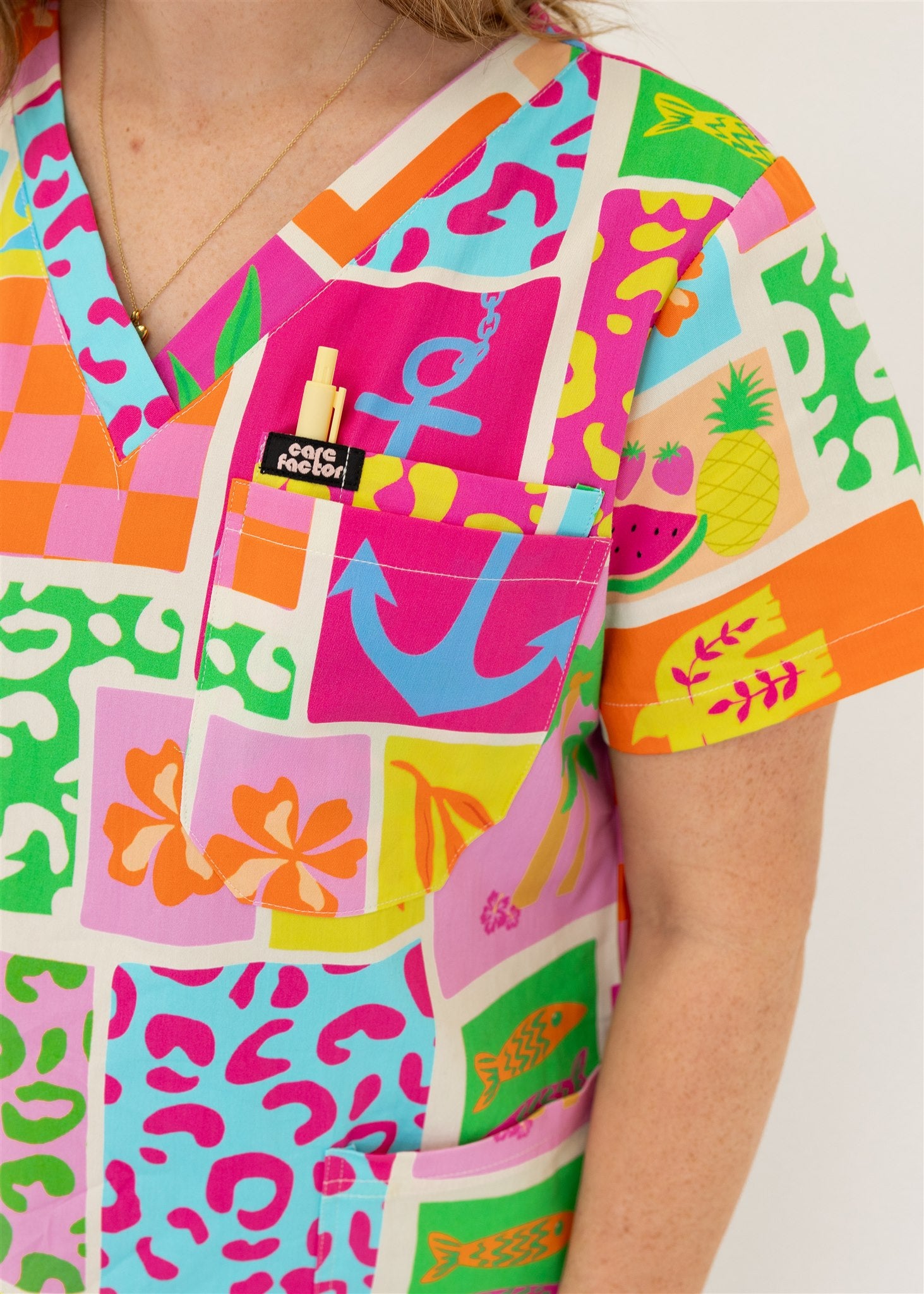 woman wearing a bright fun summery scrub set top