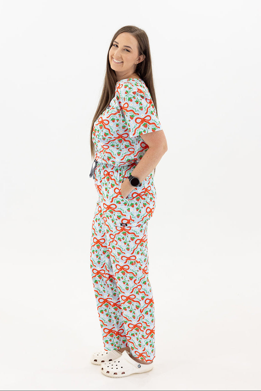woman wearing strawberry and red bow 100% cotton fun scrubs 